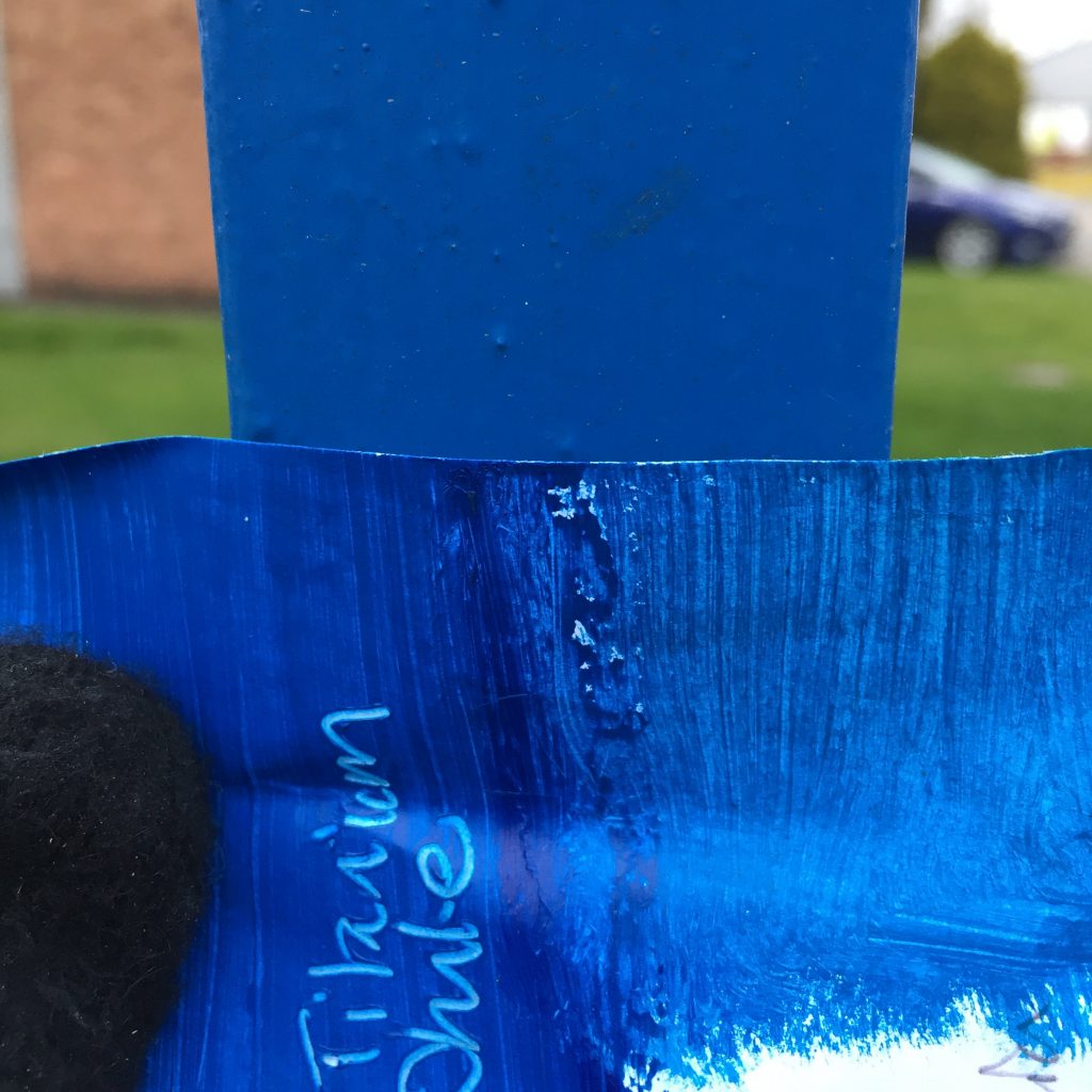Details of a blue painted fence and a paint swatch to get a colour match